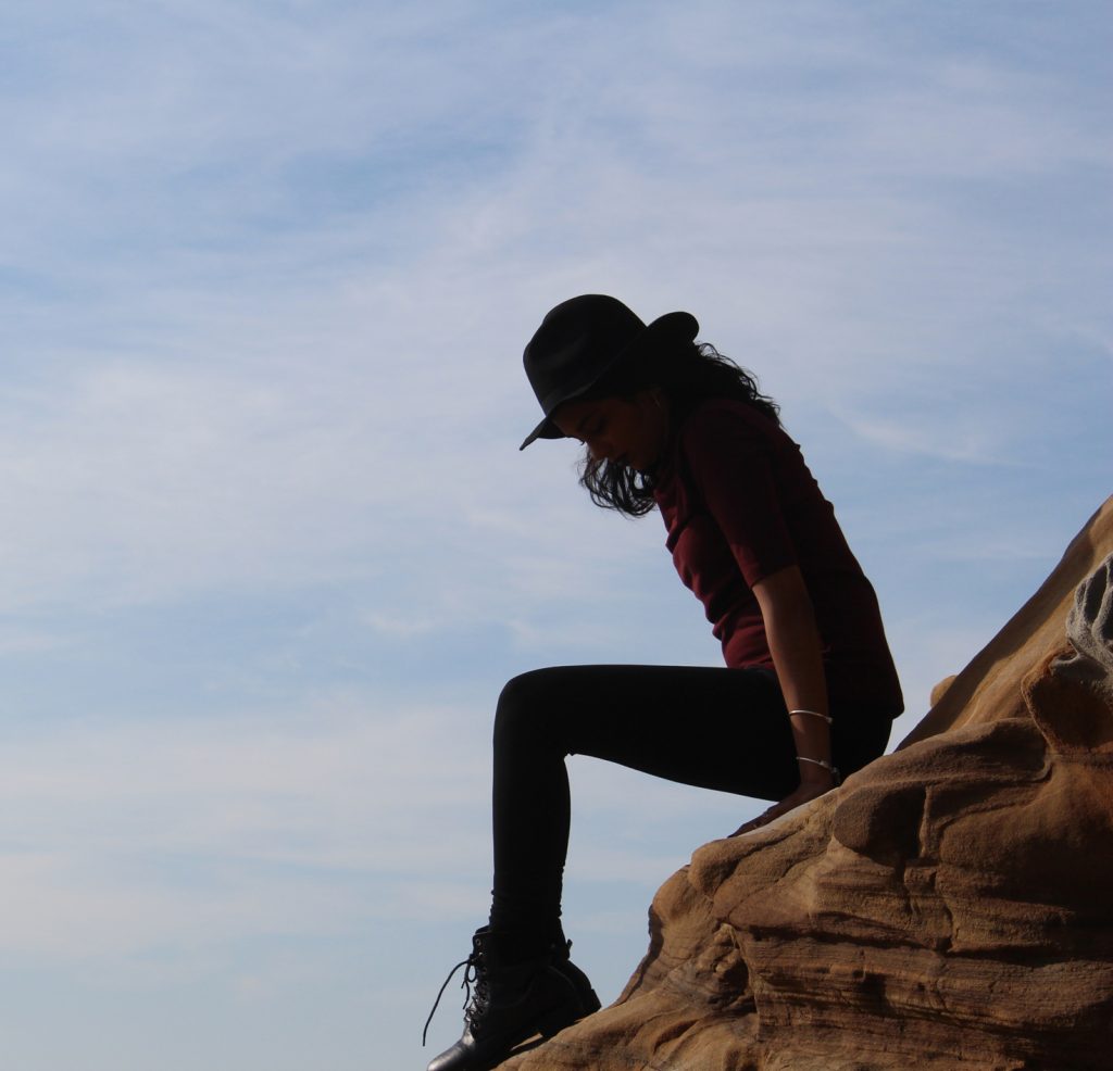 woman sitting on rock